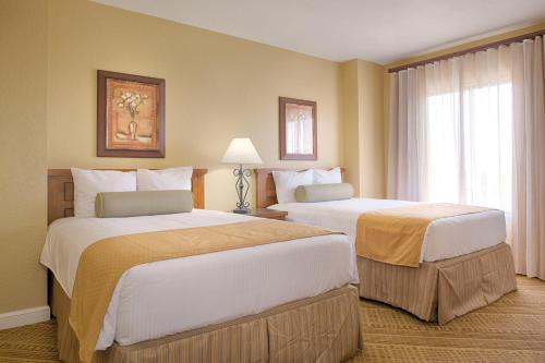 a hotel room with two beds and a window at Wyndham Bonnet Creek 2BR Apartment with Resort Access in Orlando