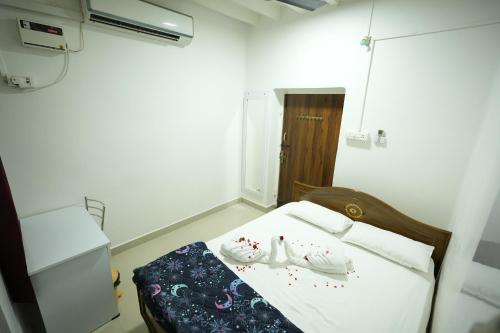 a small room with a bed with shoes on it at ABM Homestay in Thanjāvūr