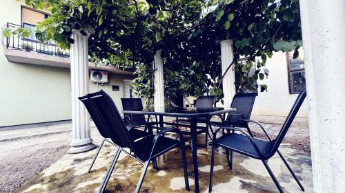 レスコヴァツにあるLucky Apartmentsの木の下に座る黒いテーブルと椅子