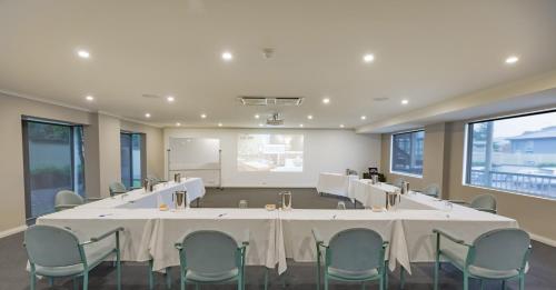 a conference room with a large table and chairs at The Waverley International Hotel in Glen Waverley
