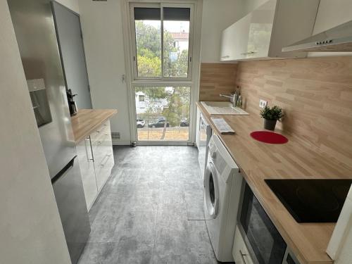 une cuisine avec laveuse et sécheuse dans l'établissement Casa 9 - Spacieux et familial, 3 chambres, 2 terrasses, climatisation et stationnement facile, à Perpignan