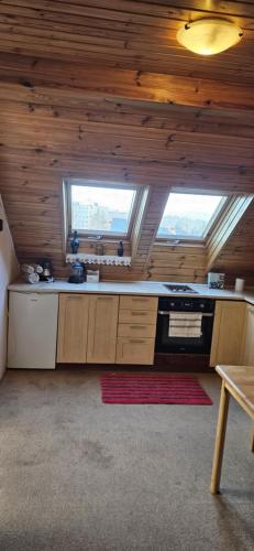 a large kitchen with wooden ceilings and a stove at Apartmán Siuzen in Brezno