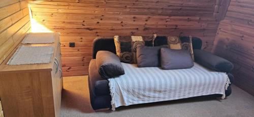 a bed in a room with a wooden wall at Apartmán Siuzen in Brezno