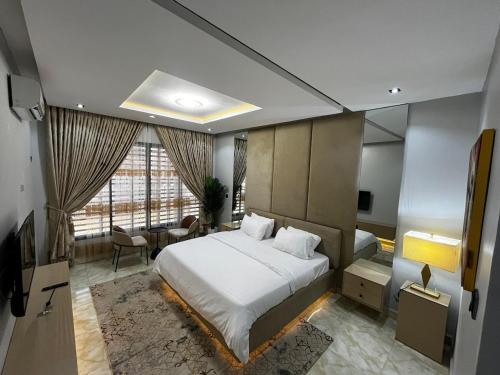 アブジャにあるLahdas Apartmentのベッドと机と窓のある寝室