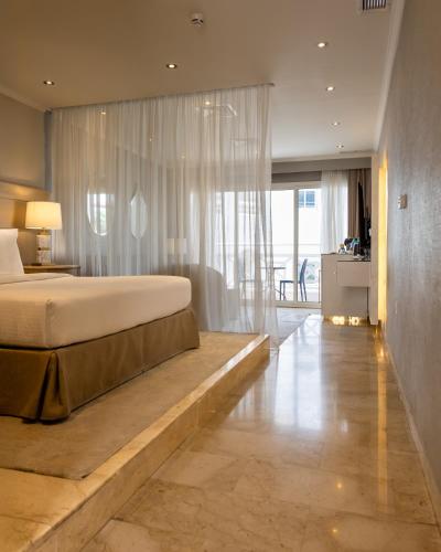 a bedroom with a large bed and a large window at Argan Al Bidaa Hotel and Resort , Kuwait in Kuwait