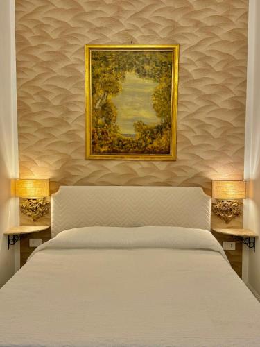a bedroom with a white bed and a painting on the wall at Villa Romilda in Ascea