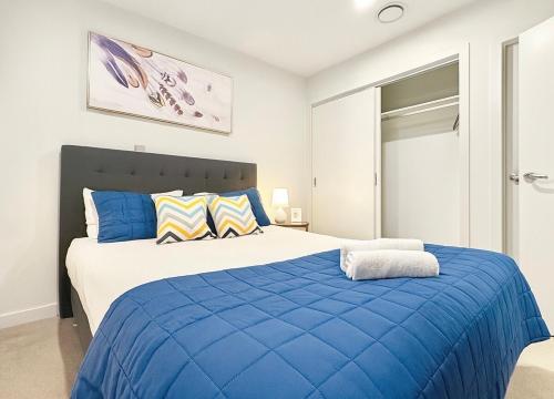 ein blau-weißes Schlafzimmer mit einem großen Bett in der Unterkunft 2BR Apt Next to Sky Tower with Pool Gym Access in Auckland