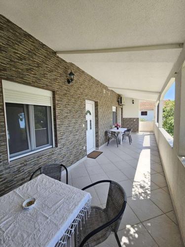a patio with a table and chairs and a brick wall at Apartmani Sutomore welcome in Sutomore