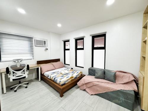 a room with a desk and a bed and a chair at Halika Villa & Capitolo events place near BGC in Manila