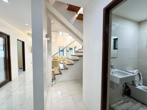 a bathroom with a sink and a staircase at Halika Villa & Capitolo events place near BGC in Manila