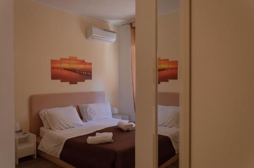 a small bedroom with a bed and a mirror at BONORUM De Spuches in Palermo