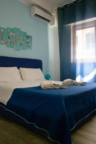 a bedroom with a bed with blue sheets and a window at BONORUM De Spuches in Palermo