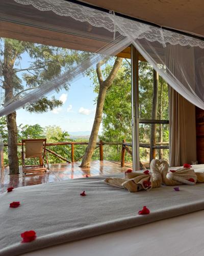 a bedroom with a bed with red rose petals on the floor at Foresight Eco Lodge & Safari in Karatu