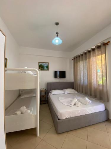 a bedroom with two bunk beds and a television at Villa Edi in Vlorë
