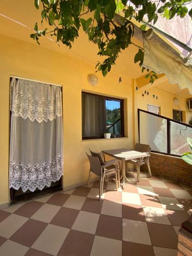 ein Zimmer mit Tisch und Stühlen und einem Fenster in der Unterkunft Villa Edi in Vlorë
