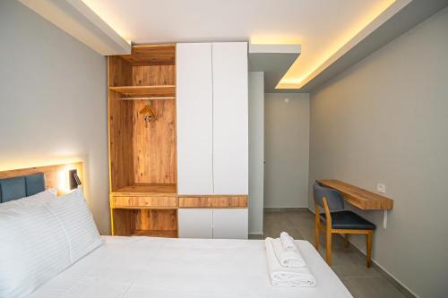 a bedroom with a white bed and a desk at Airport Bayrak Residences Trabzon in Trabzon