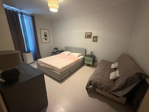a bedroom with two beds and a table and a window at Prato Home - apartment near the beach in Menton in Menton