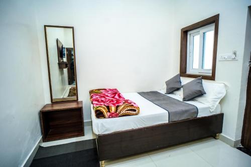 a bed in a room with a mirror at Shri Bankey Bihari Guest House in Mathura