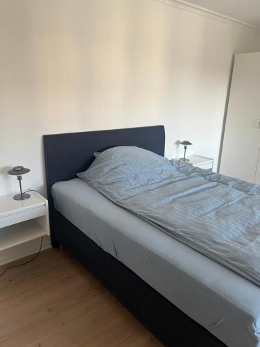 a bed in a bedroom with two lamps on tables at Lækker lejlighed på havnefronten 1 in Nakskov