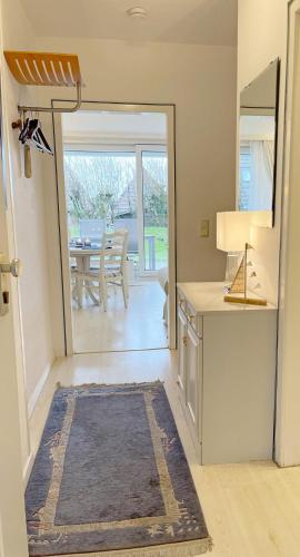 a kitchen with a table and a door to a dining room at Ferienwohnung mit Terasse Haus Calma in Wenningstedt