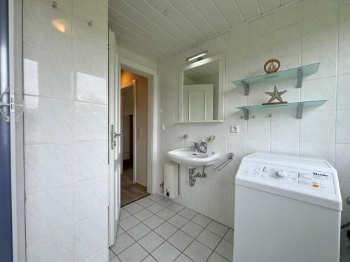 a bathroom with a sink and a washing machine at Ferienwohnung in Tinnum auf Syt in Tinnum