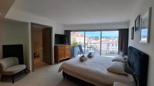 une chambre avec un grand lit et une grande fenêtre dans l'établissement Cannes Centre - Villa Lérins - Cavell Suites - Walking Distance From Palais des Festivals and Beach - Free Parking - Perfect Location For Business And Holliday, à Cannes
