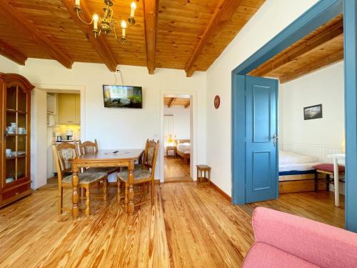 a dining room with a table and chairs and a bedroom at Haus Wolfram App Gondeline Morsumer Kliff in Archsum