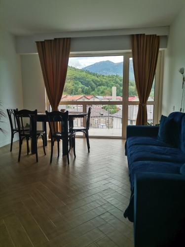 a living room with a table and chairs and a couch at Perla Sinaia in Sinaia