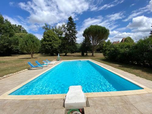 une piscine avec deux chaises longues à côté dans l'établissement La Métairie Maison de Charme porte du Périgord, à Saint-Adjutory