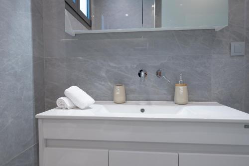 ein Badezimmer mit einem Waschbecken mit zwei Kerzen darauf in der Unterkunft Villa Jaubelli Bliss in Platánion