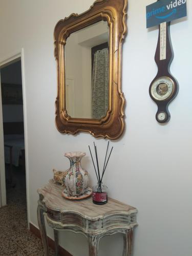 a mirror on a wall above a table with a vase at ORVIETO BRICK HOUSE in Orvieto Scalo