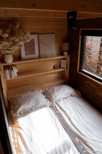 a bed in a wooden room with a window at Tiny House Mayu - Veluwe Airco 4 persons in Arnhem