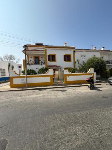a yellow and white house on the side of a street at MIRA VILA by Stay in Alentejo for HIKERS in Vila Nova de Milfontes