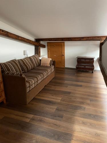 a living room with a couch and wooden floors at ART hotel MAXIM in Frýdek-Místek