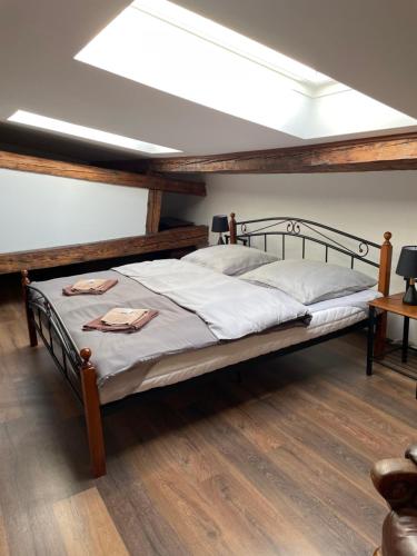 a large bed in a room with wooden floors at ART hotel MAXIM in Frýdek-Místek