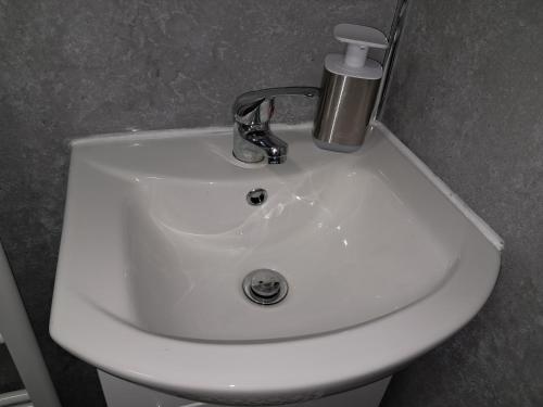 a white sink with a faucet on top of it at Robin's nest in Wilbarston