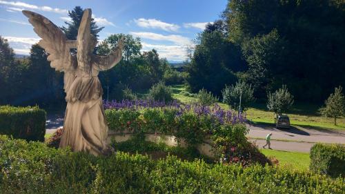 a statue of a woman in a garden with flowers at Kloster Bonlanden in Berkheim