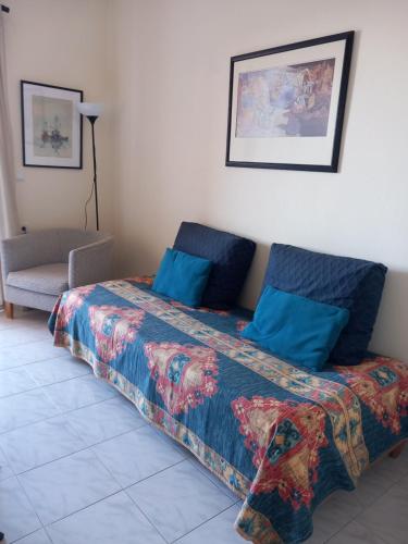 a bedroom with a bed with blue pillows at Forest & Sea Apartment in Poros