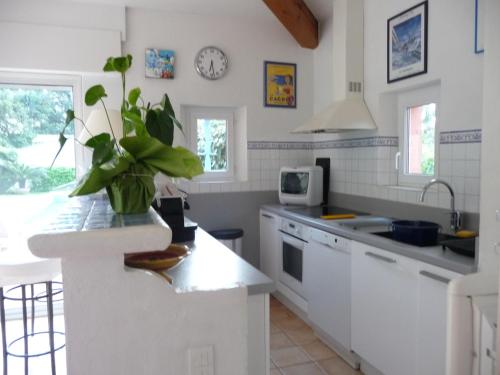 une cuisine avec des placards blancs et un comptoir blanc dans l'établissement Petite maison à l'entrée de Saint-Tropez, à Saint-Tropez