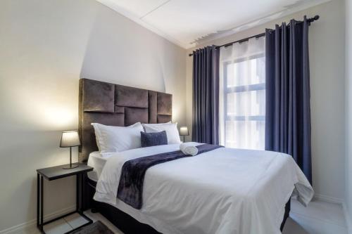 a bedroom with a large bed and a window at First Floor 2 Beds Premium Suite in Midrand