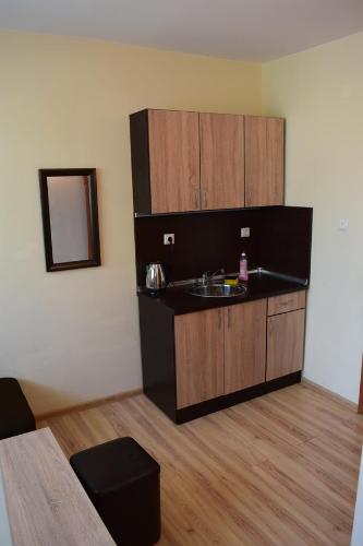 a kitchen with a sink and wooden cabinets at Guest House Sv Nikola in Ahtopol