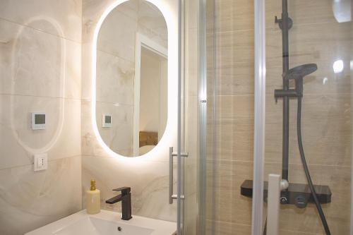 a bathroom with a sink and a shower with a mirror at Tramonto Suite in Novalja