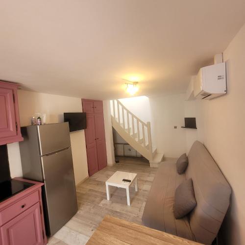 un salon avec un canapé et une cuisine avec un escalier dans l'établissement Détente et plaisir à Taltahull, à Tautavel