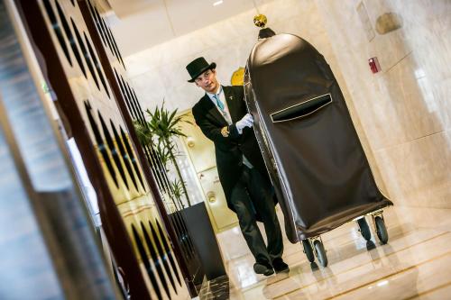 a man in a suit and hat standing in a elevator at Jannah Burj Al Sarab in Abu Dhabi
