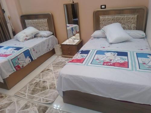 1 Schlafzimmer mit 2 Betten und Hello-Kitty-Bettwäsche in der Unterkunft Apartment in Madinaty Cozy in Madinaty
