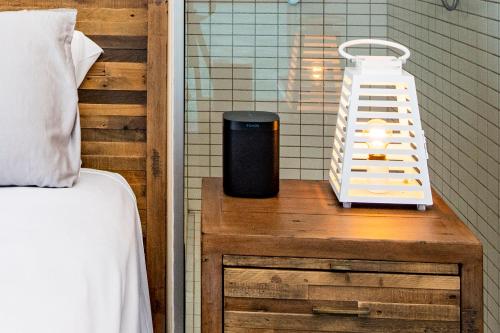 a room with a bed and a nightstand with a lamp at Luxury Oceanview Escape in Nelly Bay
