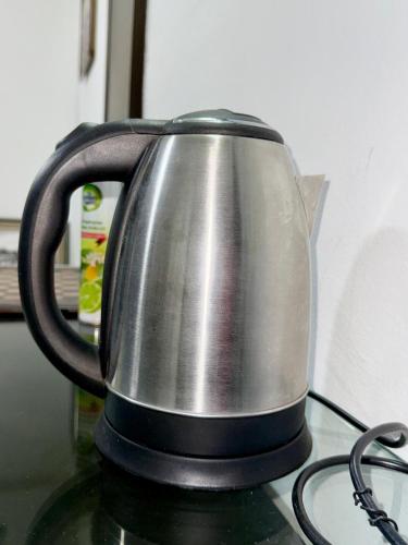 a tea kettle sitting on top of a stove at Chic appartement à la Riviera Palmeraie in Abidjan