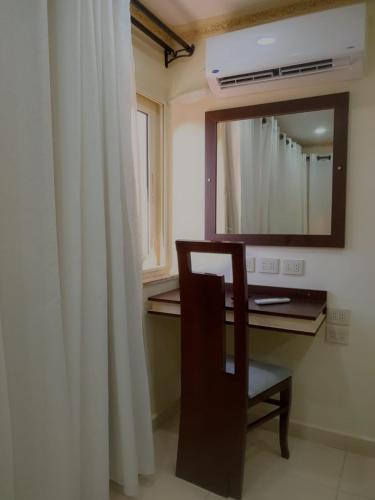 a bathroom with a desk with a mirror and a chair at زافيرو شارع فؤاد in Alexandria