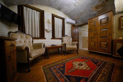 a living room with two chairs and a rug at Harman Cave Hotel in Goreme