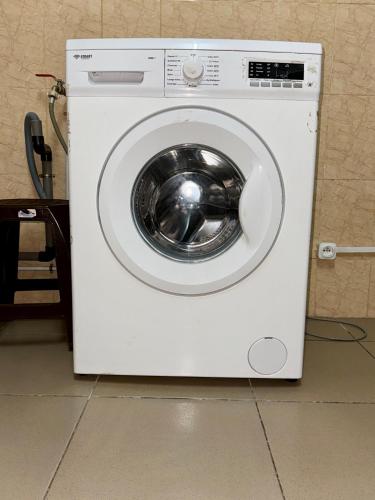 a white washing machine sitting in a room at Chic appartement à la Riviera Palmeraie in Abidjan